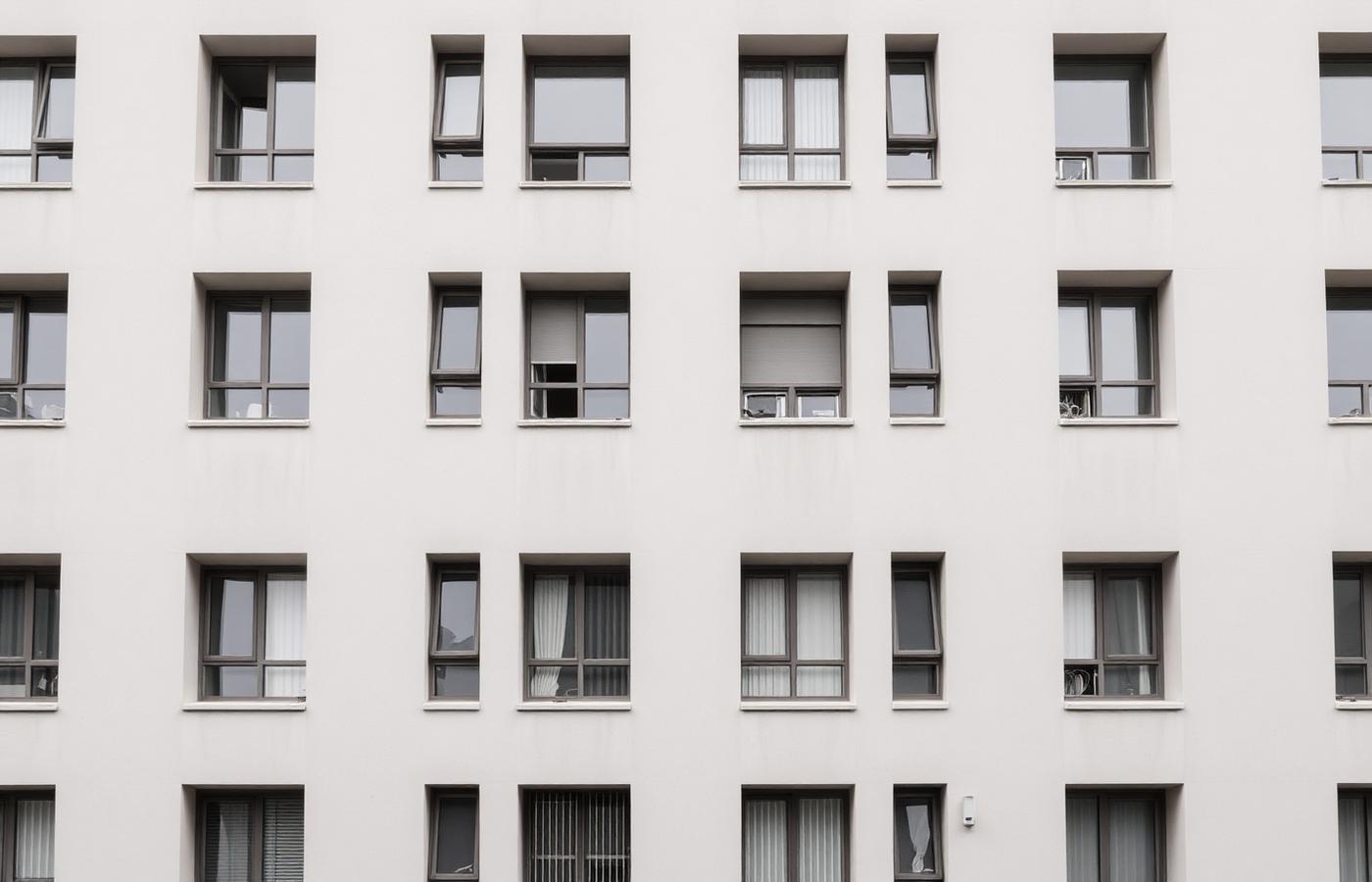 Fassade eines mehrgeschossigen Wohngebäudes mit gleichmäßigem Fensterraster